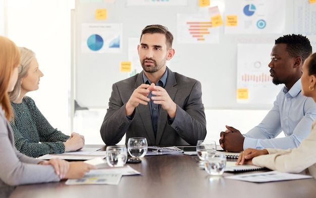 En företagsledare presenterar finansiell strategi för sitt team under ett möte.